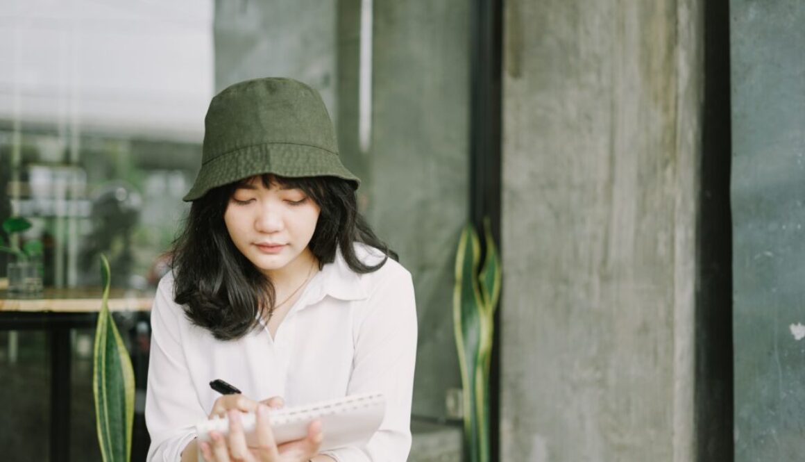 Lady wearing hat writing notes